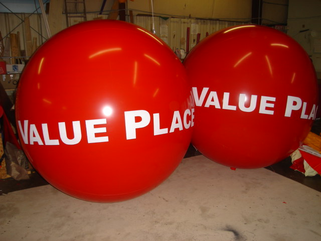 red advertising air balloons with white lettering
